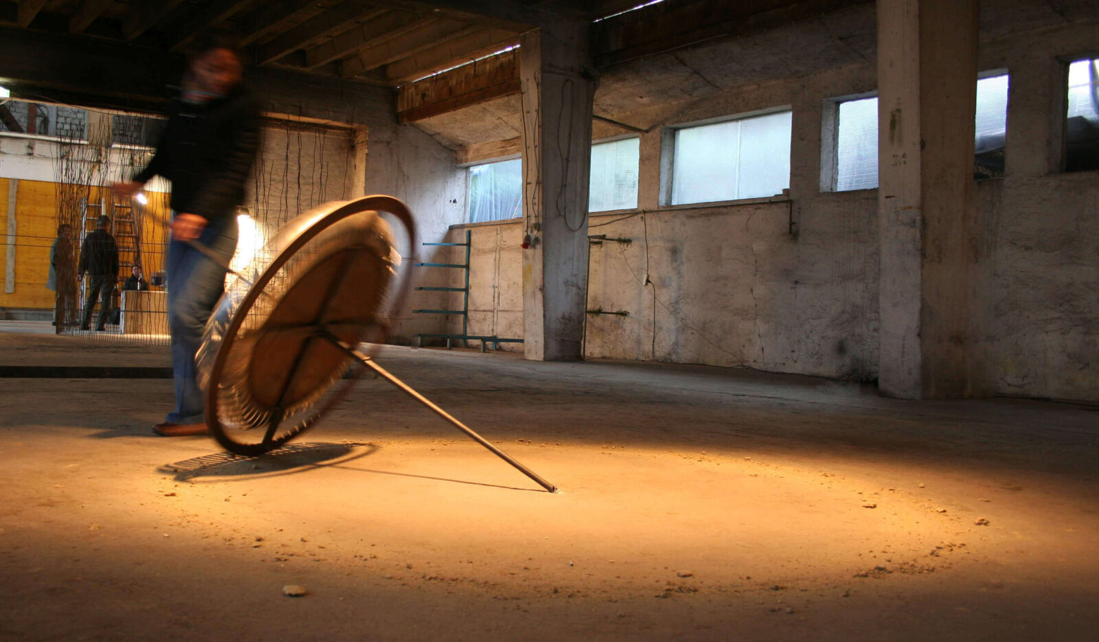 Detail view of a circular interactive sculpture, showing tensioned elements and material deformation under pressure.