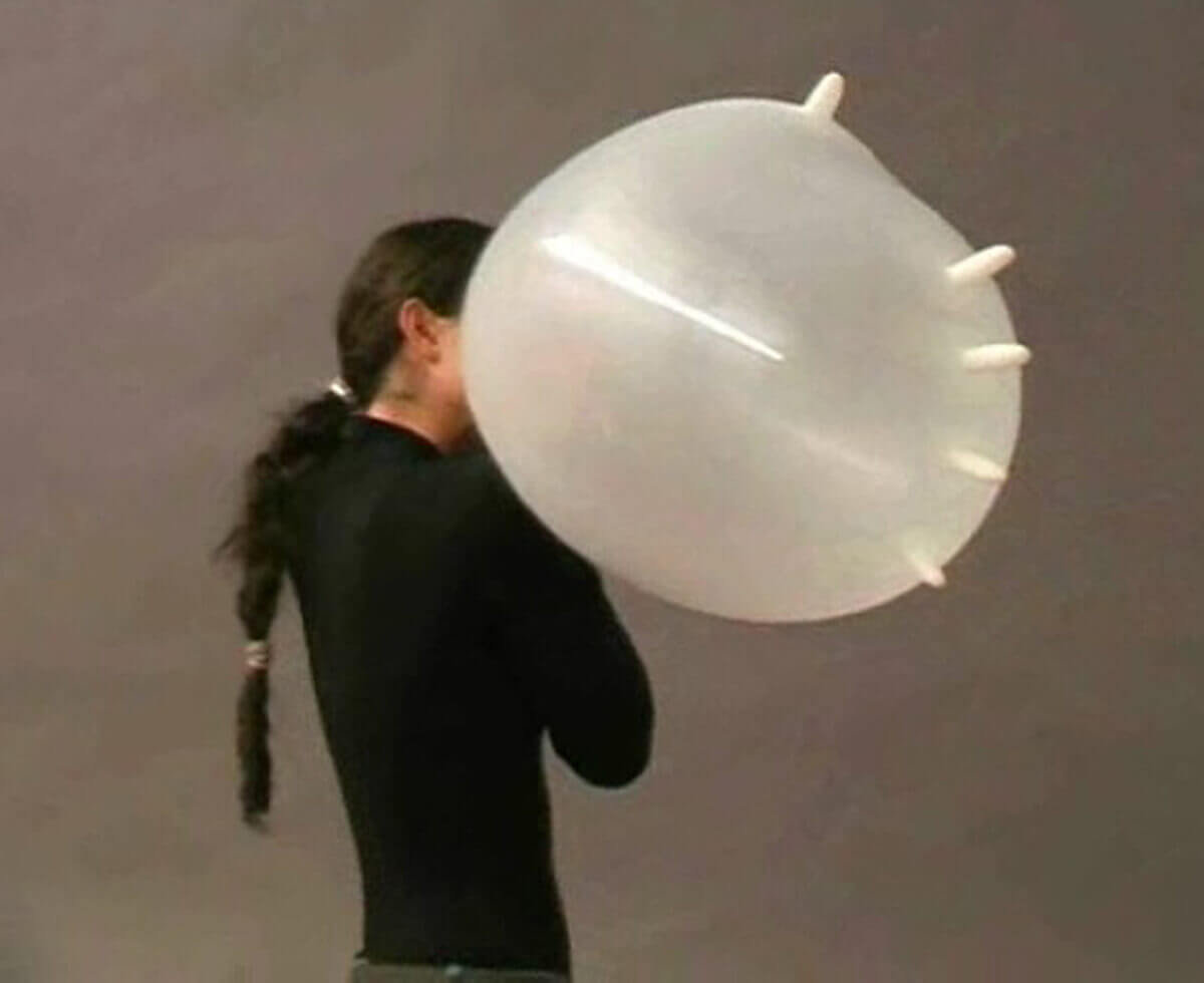 Rear view of a performer holding an inflated white latex glove during a live action.