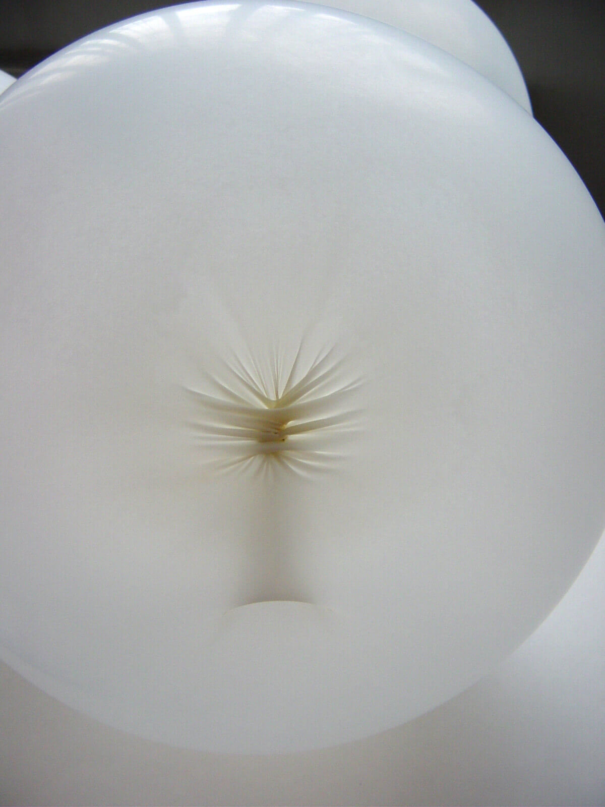 Sculptural object composed of inflated white latex gloves arranged in a clustered formation.